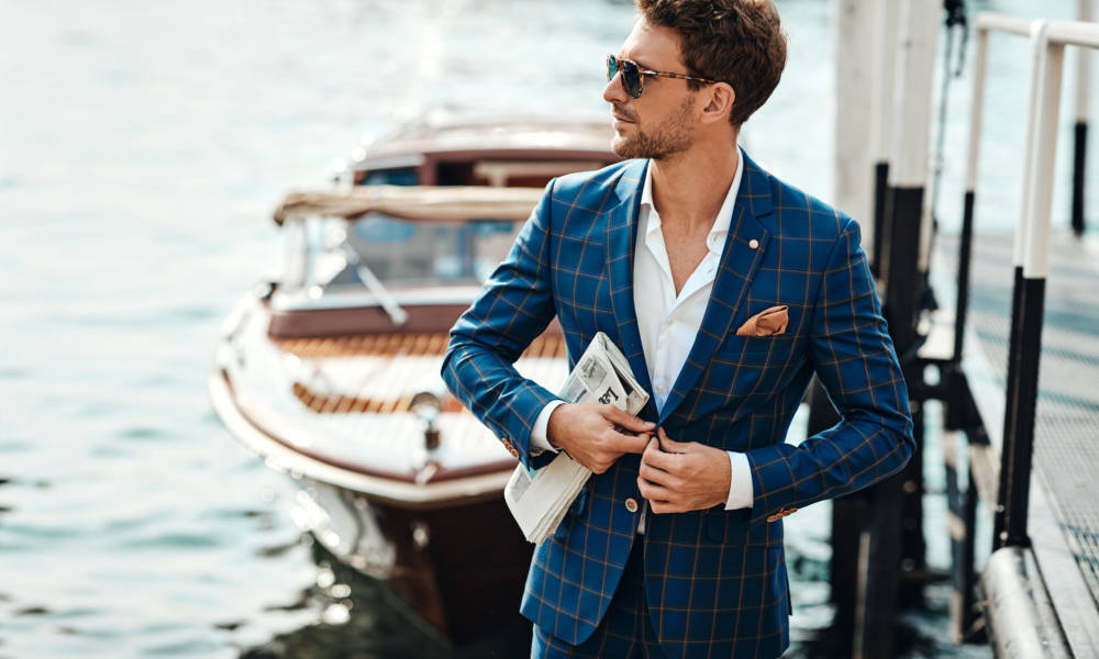 Young handsome man in classic suit over the lake background